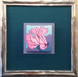 A picture of a pink flower in a silver frame